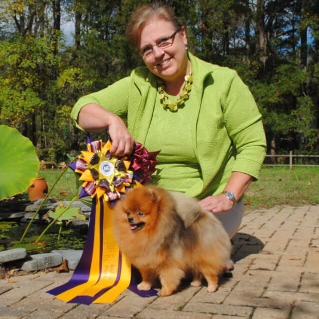 Gretchen King with a Pomeranian and show ribbon